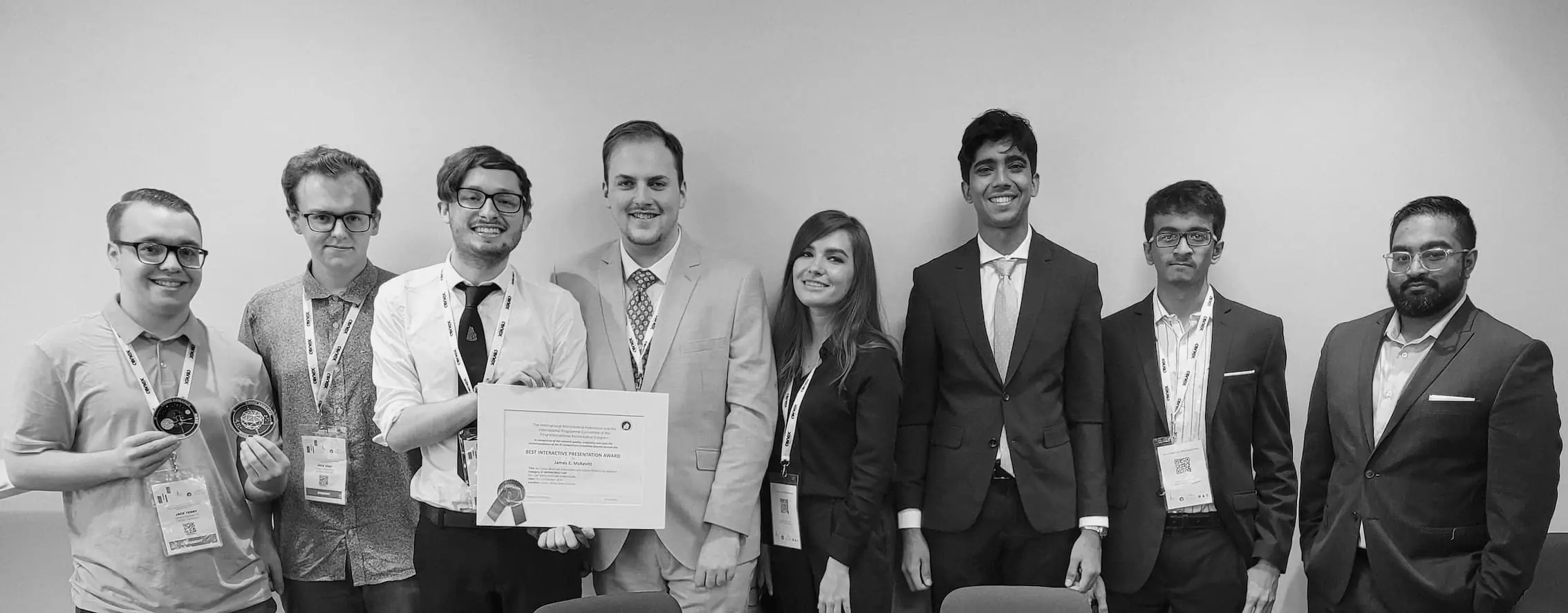 Greyscale photo of the Conex team with an award certificate