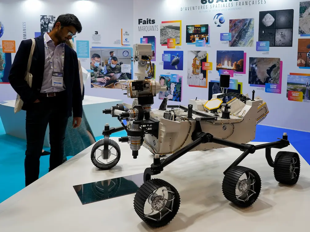 Shayne Beegadhur looking at a model rover on display at IAC 2022